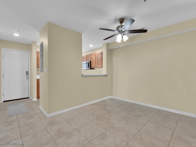 empty room with light tile patterned floors and ceiling fan