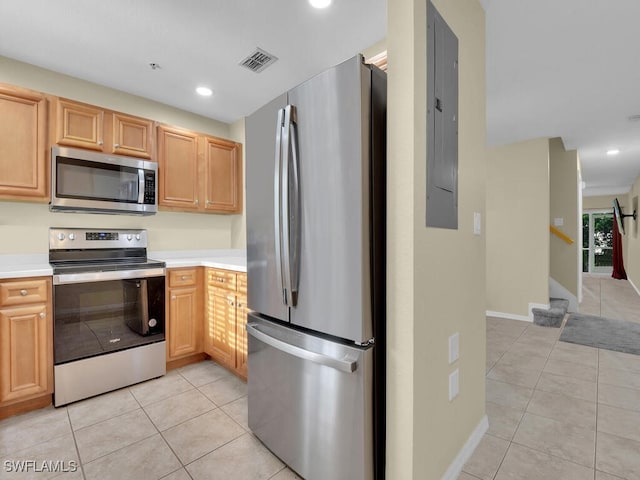 kitchen featuring light tile patterned floors, electric panel, stainless steel appliances, and light brown cabinetry