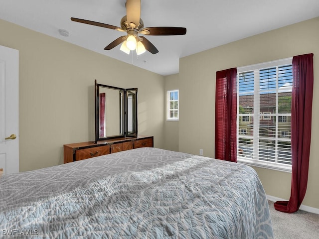 carpeted bedroom with multiple windows and ceiling fan