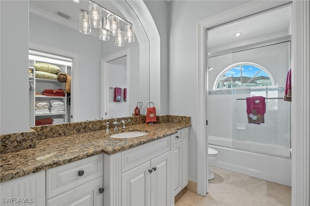 full bathroom featuring toilet, combined bath / shower with glass door, ornamental molding, and vanity