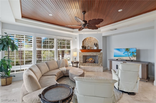 living room with a raised ceiling, wood ceiling, and a fireplace