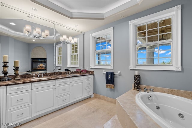 bathroom featuring vanity, tile patterned floors, a raised ceiling, a relaxing tiled tub, and ornamental molding