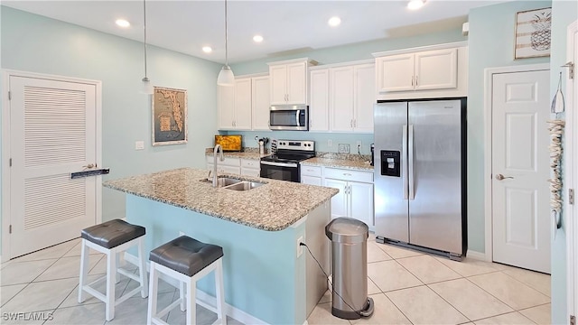 kitchen featuring sink, stainless steel appliances, white cabinetry, and a kitchen island with sink