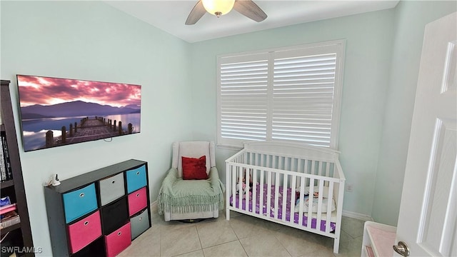 tiled bedroom with ceiling fan, a crib, and multiple windows