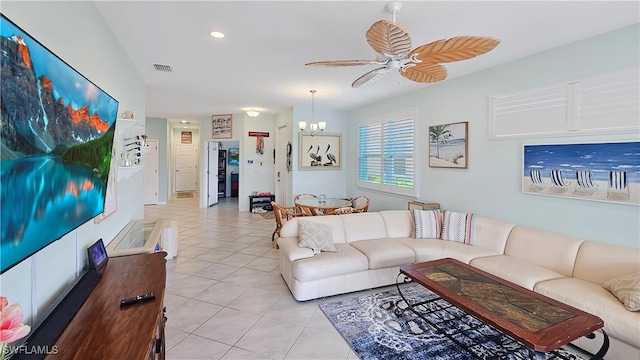 tiled living room with ceiling fan with notable chandelier