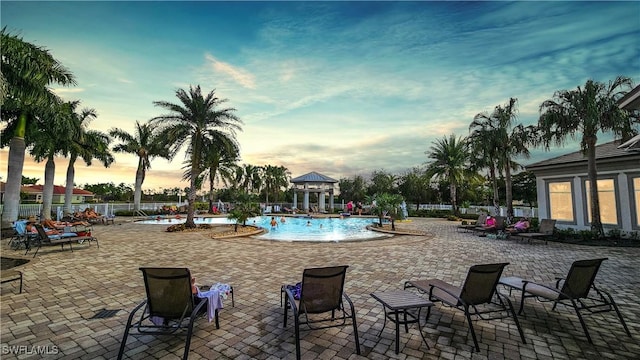 pool at dusk with a patio