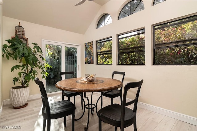 dining area with light hardwood / wood-style floors and vaulted ceiling