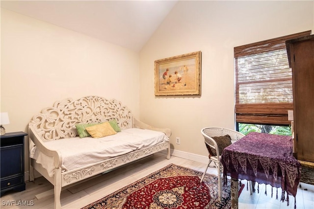 bedroom featuring hardwood / wood-style flooring, vaulted ceiling, and multiple windows