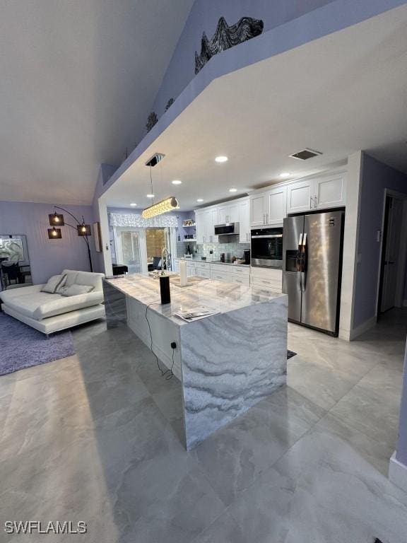 kitchen featuring pendant lighting, white cabinets, decorative backsplash, appliances with stainless steel finishes, and light stone counters