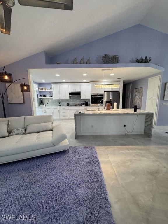 living room featuring high vaulted ceiling and sink