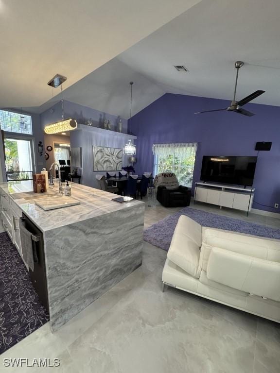 interior space featuring ceiling fan, high vaulted ceiling, and a healthy amount of sunlight