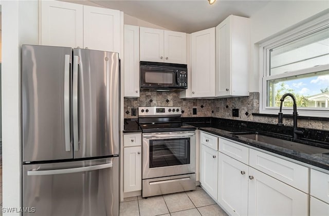 kitchen with white cabinetry, vaulted ceiling, and appliances with stainless steel finishes