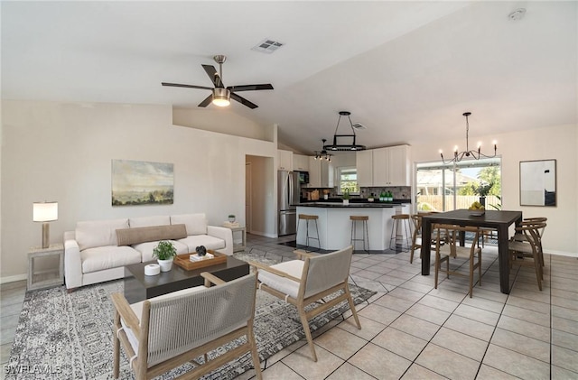 tiled living room featuring ceiling fan with notable chandelier and lofted ceiling