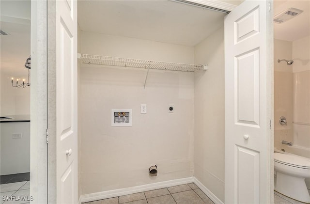 washroom with washer hookup, an inviting chandelier, electric dryer hookup, and light tile patterned flooring