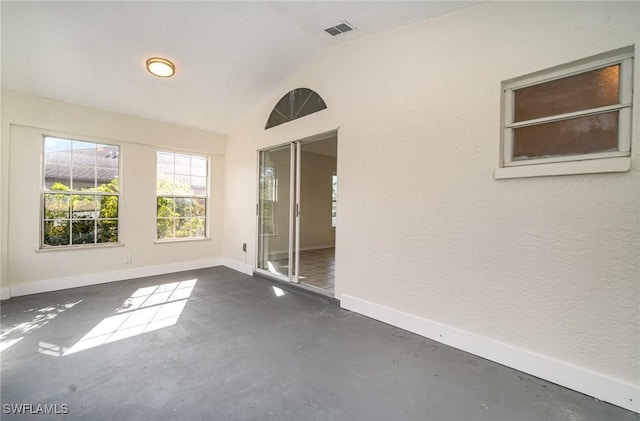 unfurnished room featuring lofted ceiling