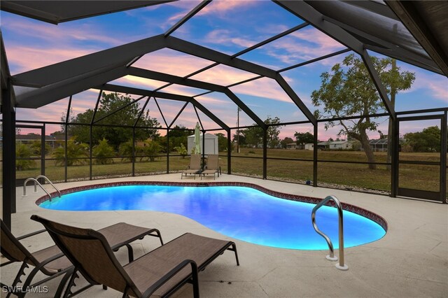 pool at dusk with a yard, a lanai, and a patio