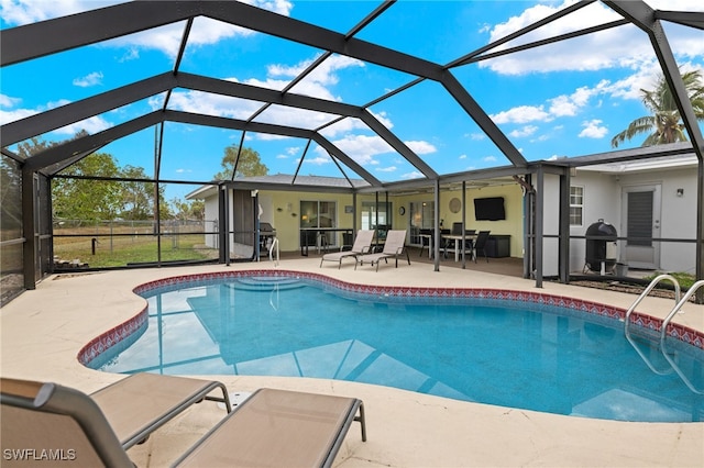 view of pool featuring a grill, glass enclosure, and a patio area