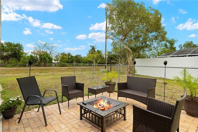 view of patio with an outdoor living space with a fire pit