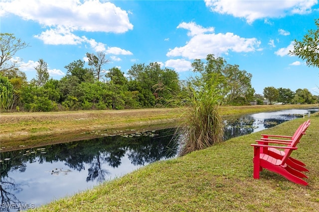 surrounding community with a yard and a water view