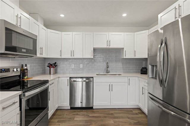 kitchen with tasteful backsplash, white cabinetry, appliances with stainless steel finishes, and sink