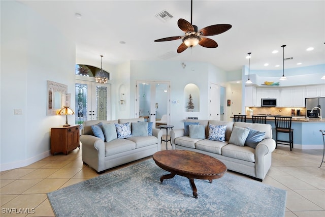 living area with light tile patterned floors, visible vents, french doors, and baseboards