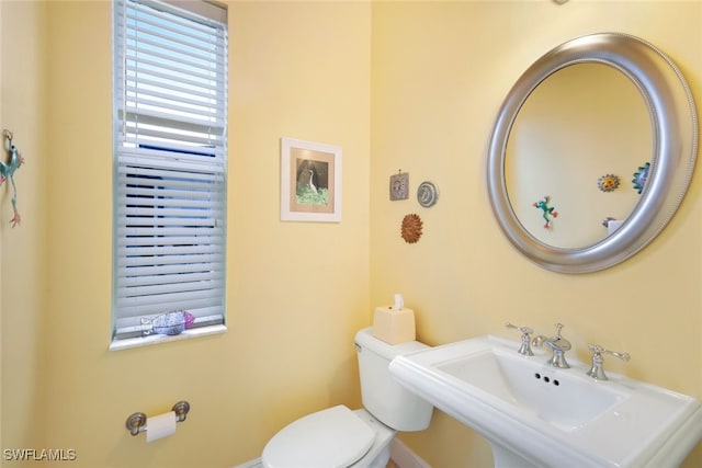 half bathroom featuring toilet and a sink