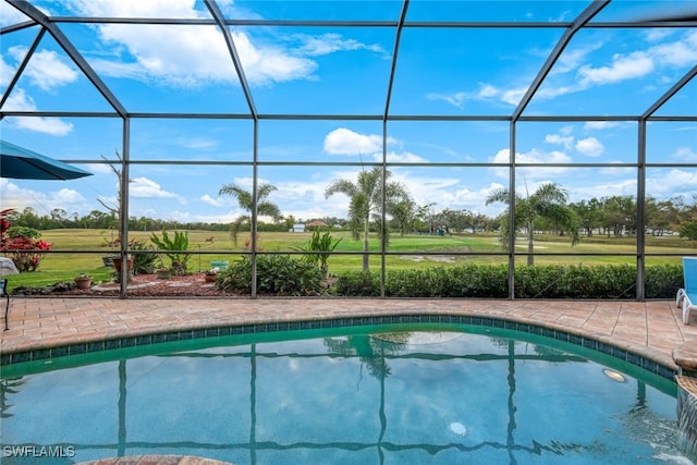 view of swimming pool featuring glass enclosure and a patio