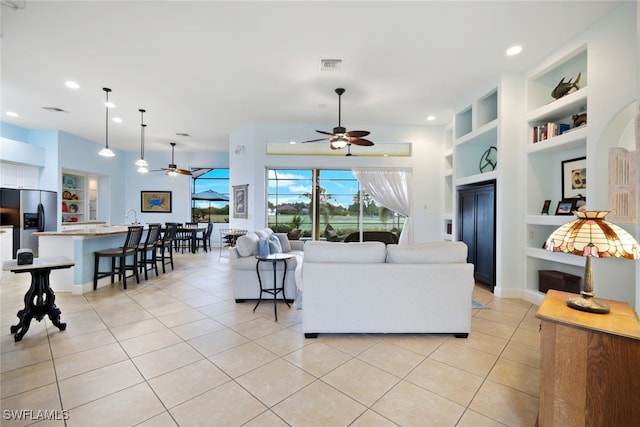 tiled living room with built in features and ceiling fan