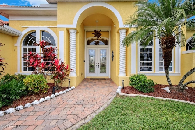 doorway to property featuring french doors and stucco siding