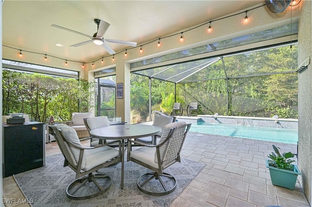 view of patio with ceiling fan and glass enclosure