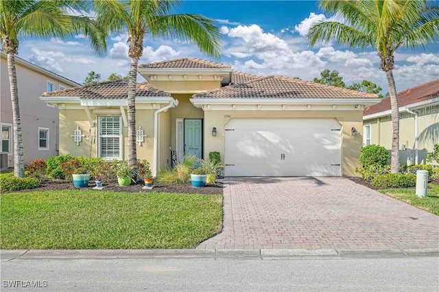 mediterranean / spanish-style home with a garage and a front lawn