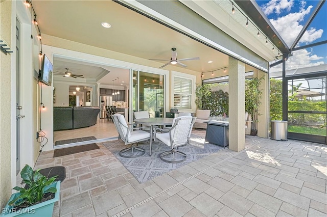 view of patio featuring glass enclosure and ceiling fan