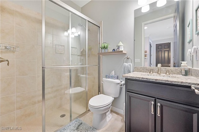 bathroom featuring tile patterned flooring, vanity, toilet, and a shower with door