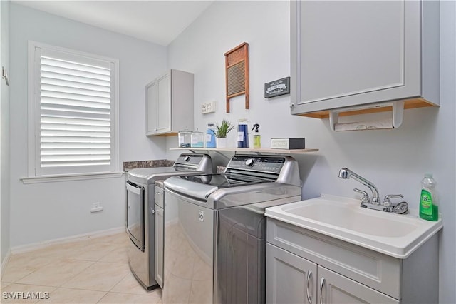 laundry area featuring washer and clothes dryer, light tile patterned flooring, cabinets, and sink