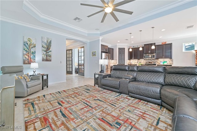 tiled living room with ceiling fan and crown molding