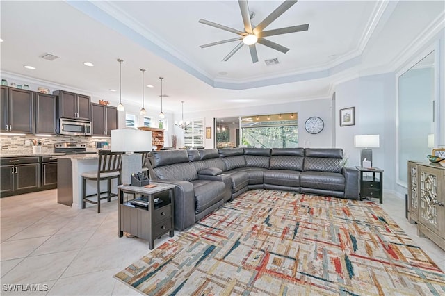 tiled living room featuring ceiling fan, crown molding, and a tray ceiling