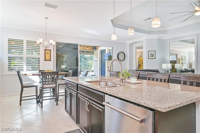 kitchen featuring dishwasher, sink, light stone counters, an island with sink, and pendant lighting