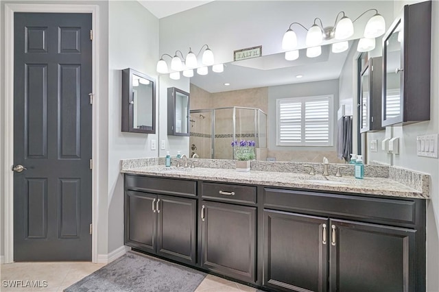 bathroom with tile patterned floors, vanity, and a shower with shower door