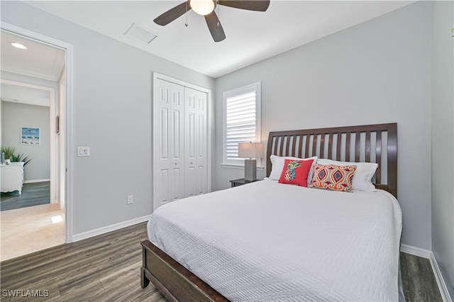 bedroom featuring dark hardwood / wood-style flooring, ceiling fan, and a closet