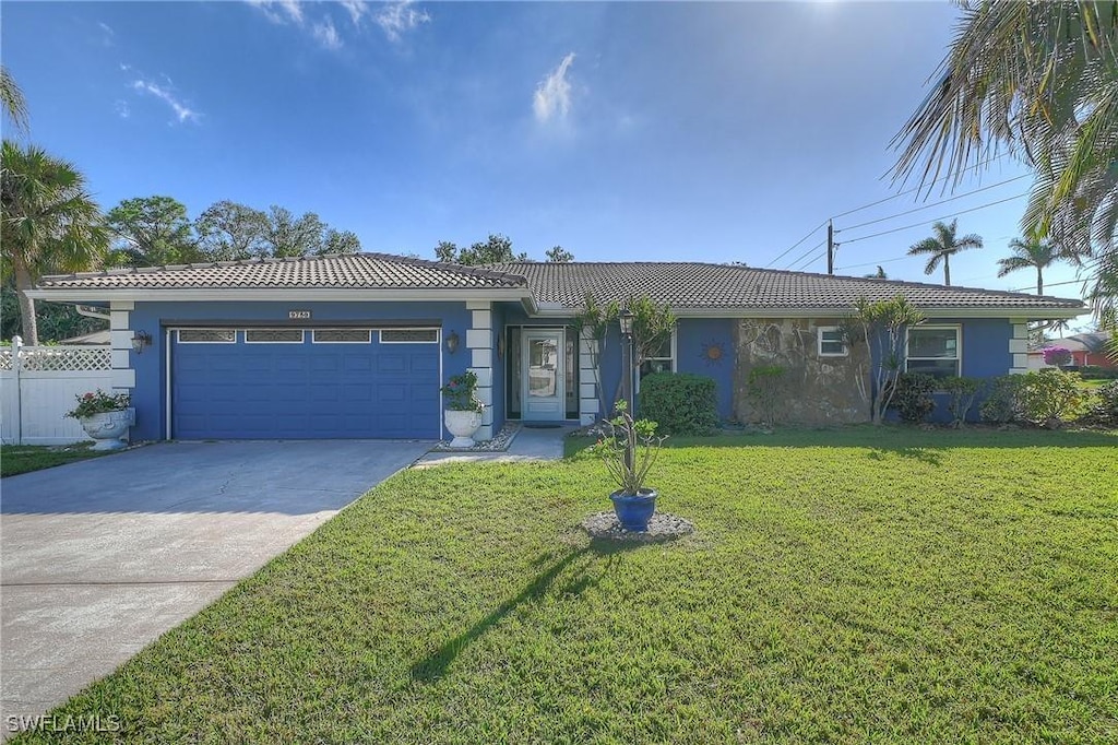 ranch-style home featuring a garage and a front lawn