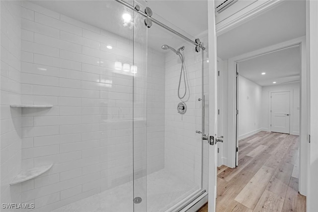 bathroom with a stall shower, baseboards, and wood finished floors