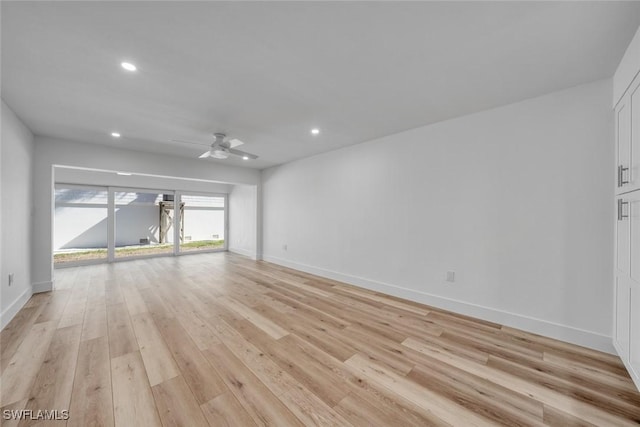 spare room with light wood-style floors, ceiling fan, and baseboards