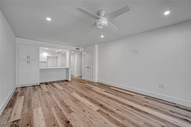 unfurnished living room with light wood-type flooring, ceiling fan, baseboards, and recessed lighting