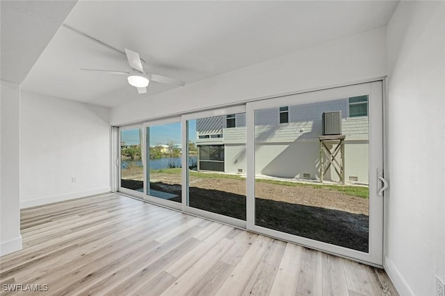 unfurnished sunroom with a water view and ceiling fan