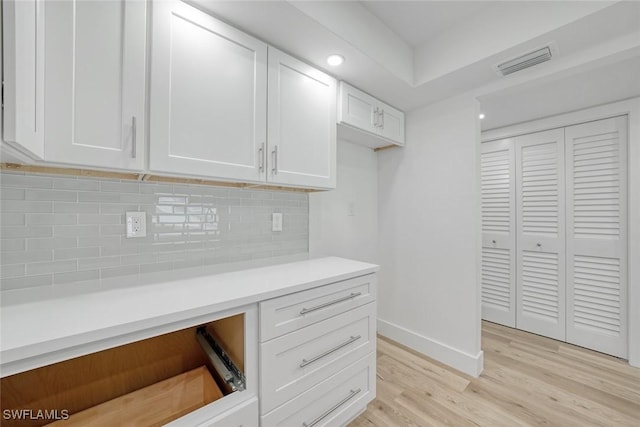 office space with light wood-type flooring, visible vents, baseboards, and recessed lighting