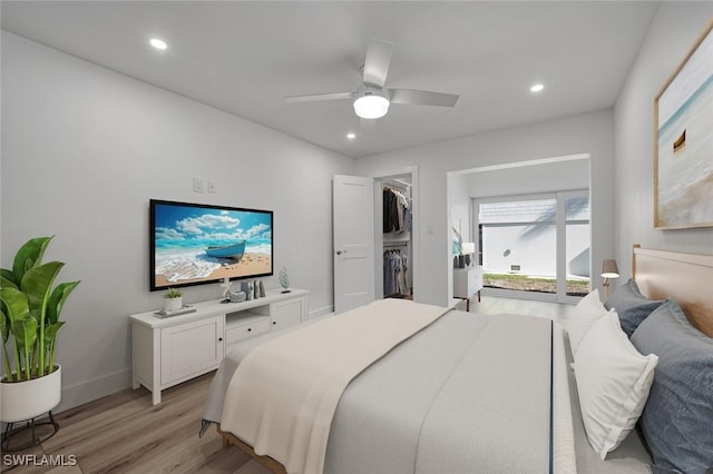 bedroom with a walk in closet, light wood finished floors, recessed lighting, ceiling fan, and baseboards