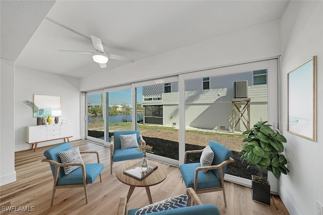 sunroom with a water view and ceiling fan