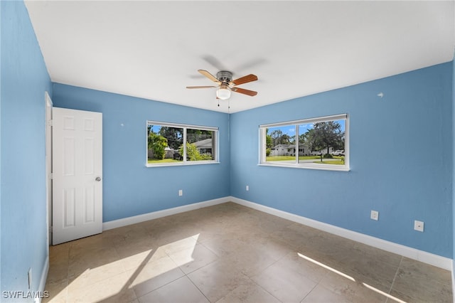 tiled spare room featuring ceiling fan