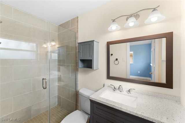 bathroom with an enclosed shower, vanity, and toilet