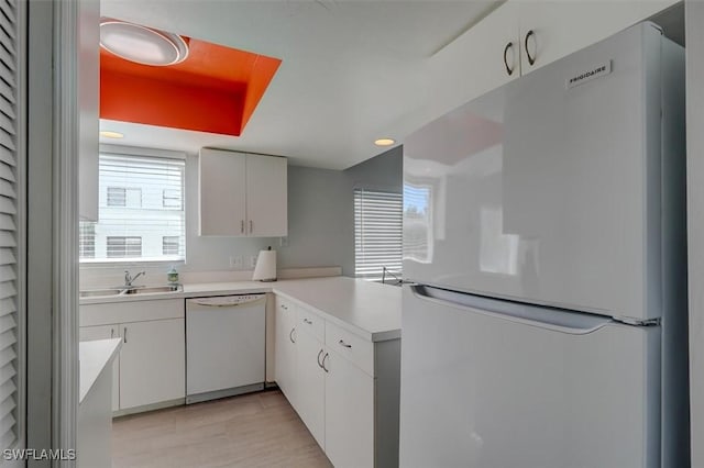 kitchen featuring white cabinets, white appliances, and sink